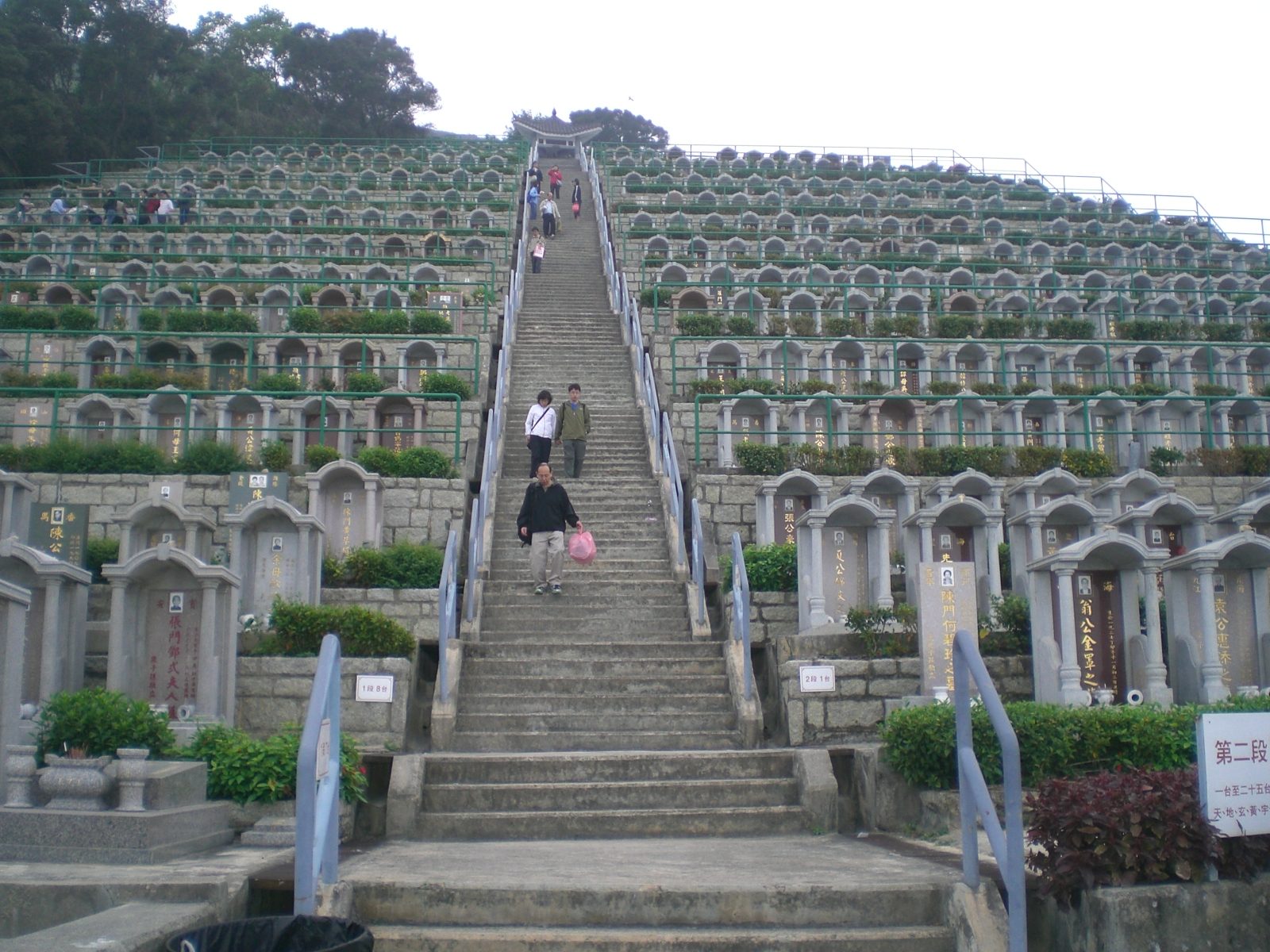 Terraced graves and the central stairway of Tseung Kwan O Chinese Permanent Cemetery, Hong Kong — the cemetery where Mui Kai-ming told reporters on 7 September 2026 he would bury his mother, Tam Mei-kam, with a permanent plot listed at HK$418,880