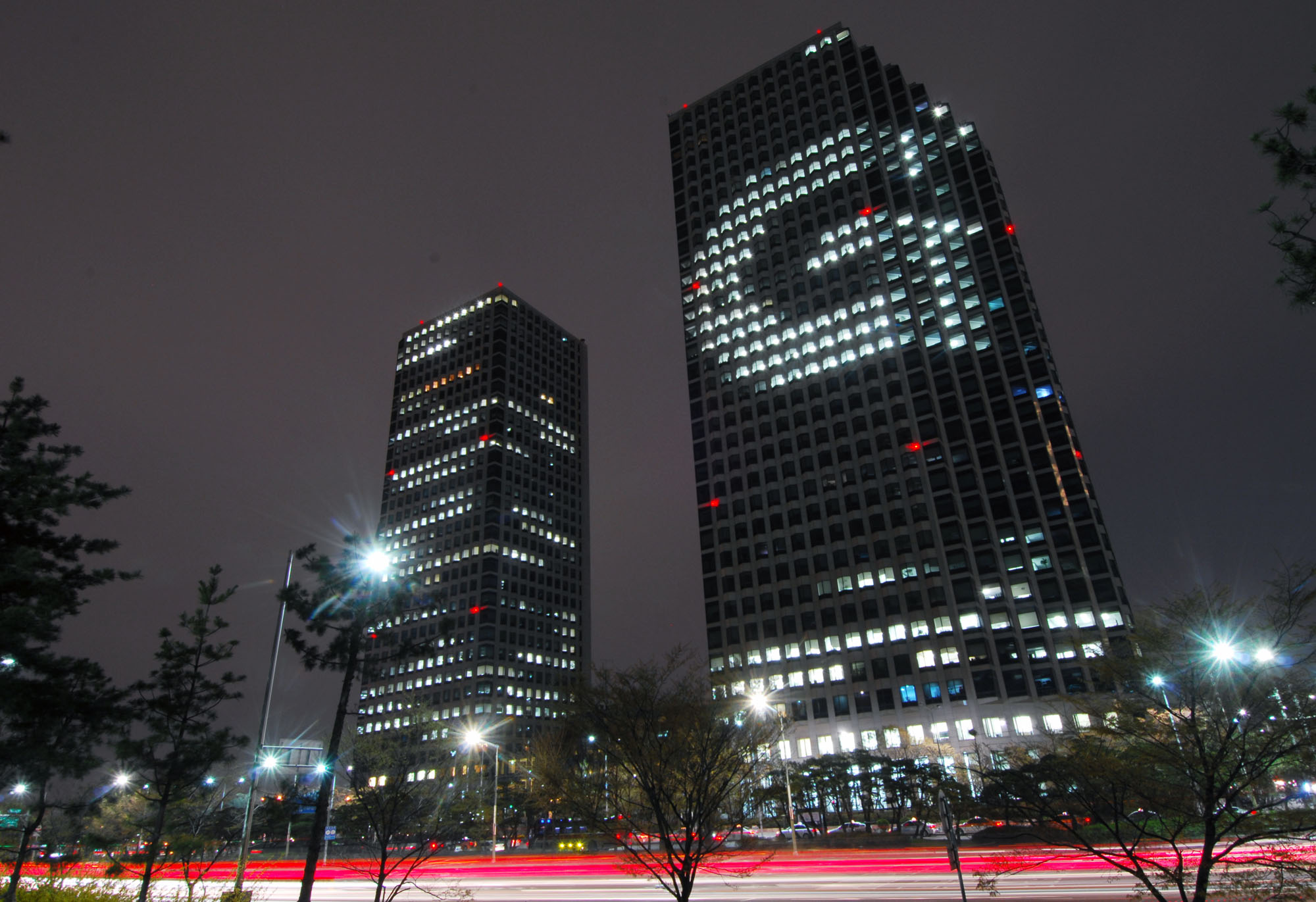 The LG Twin Towers on Yeouido, Seoul, at night, with the letter G picked out in the lit windows of the west tower — the headquarters of LG Corp, the holding company whose 11.28 per cent block is the subject of the Koo family's inheritance appeal