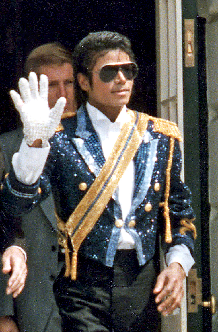 Michael Jackson waves from a White House doorway on 14 May 1984, in a sequinned jacket and one white glove. His 2002 will named three executors and set no rate of pay; in October 2026 his daughter contested a $109 million fee request